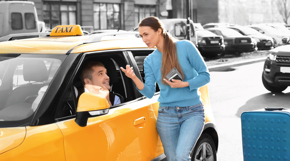 une femme parle à un chauffeur de taxi