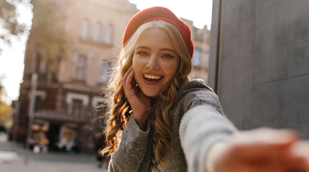 Une jeune femme parisienne heureuse appelle un taxi