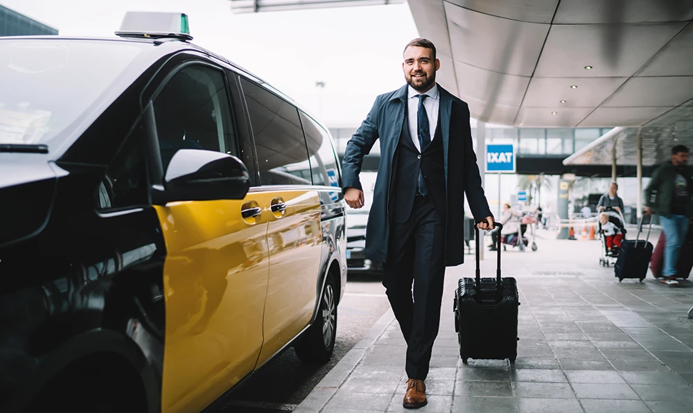 un client rejoint son taxi à la sortie de l'aéroport